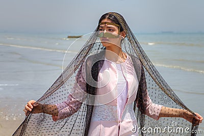 Young muslim woman wears gold mask, Hormozgan province, southern Stock Photo