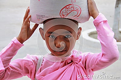 Young Myanmar nun carrying rice Editorial Stock Photo