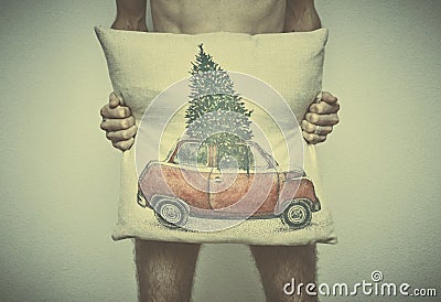 A young naked man covers his with a pillow with a Christmas themed pattern. business after New year Stock Photo