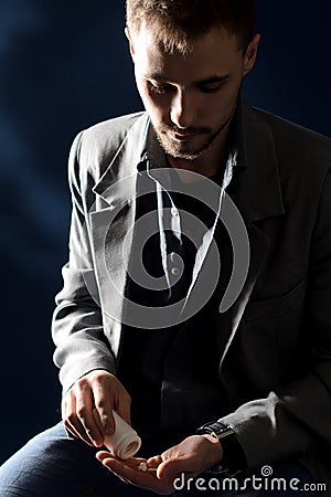 Young negligent man taking medicine Stock Photo