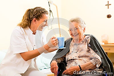 Young nurse and female senior in nursing home Stock Photo