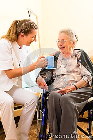Young nurse and female senior in nursing home Stock Photo