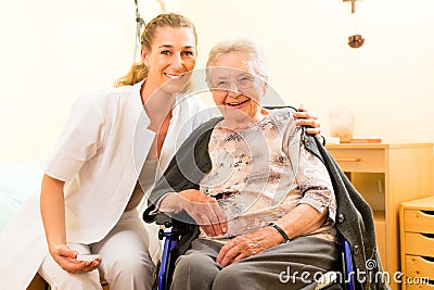 Young nurse and female senior in nursing home Stock Photo