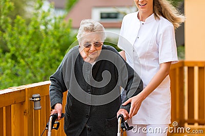 Young nurse and female senior with walking frame Stock Photo