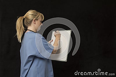 Young nurse in twenties writing on a white board Stock Photo