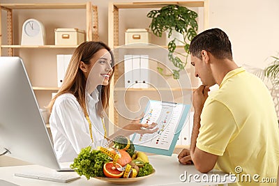 Young nutritionist consulting patient at table Stock Photo