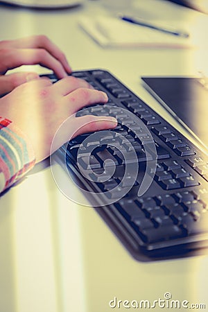 Young office worker typing on pc keyboard responses to emails. Stock Photo