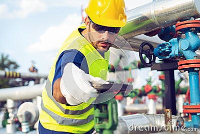 Oil worker turning valve on oil rig Stock Photo