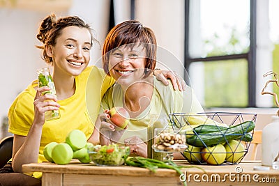 Young and older women with healthy food indoors Stock Photo