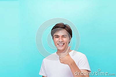 Young optimistic man isolated on blue background showing thump up with positive emotions of content and happiness. Concept of Stock Photo