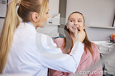 Young orthodontist checking patient in dentist`s office Stock Photo