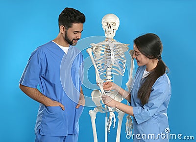 Young orthopedists with human skeleton model on background Stock Photo