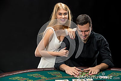 Young Ñouple playing poker. Man taking poker chips after winning Stock Photo