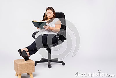 Young overweight woman accountant in glasses working in office, making notes in diary, filing taxes, providing outsource Stock Photo