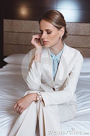 young overworked businesswoman sitting on bed Stock Photo