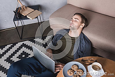 young overworked man sleeping on floor Stock Photo