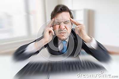 Young overworked man is tired by working with compuiter and suffering from headache Stock Photo