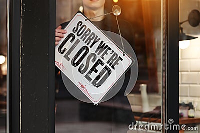 Young owner man turning signboard to closed coffee shop, owner close store or restaurant temporary due pandemic of Stock Photo