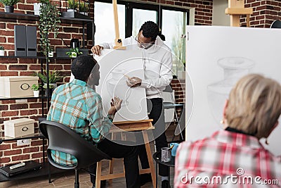 Young painter teacher helping student with drawing process during art class Stock Photo