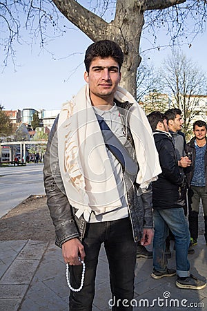 Young Pakistan Refugee, a Young Man, posing with people from Afghanistan, in background in a Belgrade park, during refugee crisis Editorial Stock Photo