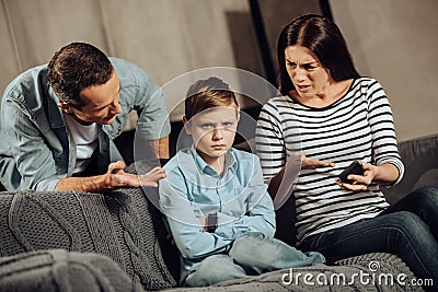 Young parents explaining son about drawbacks of binge-playing Stock Photo