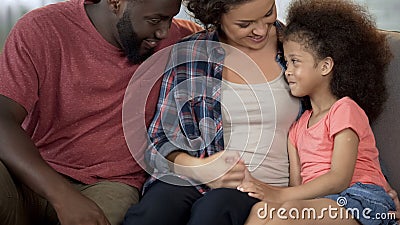 Young parents find approach to shy adopted child, loving and caring family Stock Photo