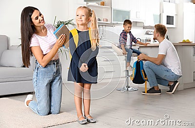 Young parents helping little children to prepare for school Stock Photo