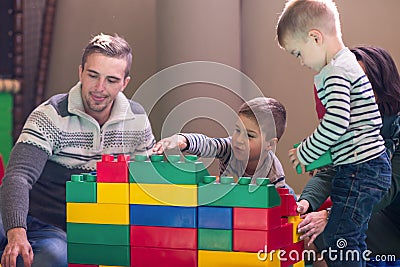 Young parents and kids having fun at childrens playroom Stock Photo