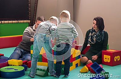 Young parents and kids having fun at childrens playroom Stock Photo