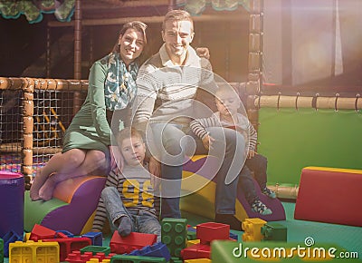 Young parents and kids having fun at childrens playroom Stock Photo