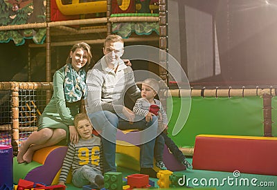 Young parents and kids having fun at childrens playroom Stock Photo