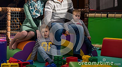 Young parents and kids having fun at childrens playroom Stock Photo