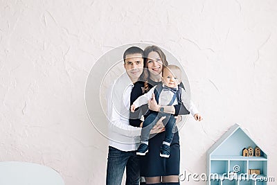 Young parents stand and pose with their toddler boy Stock Photo