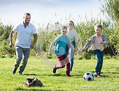 Young parents with two kids playing soccer Stock Photo