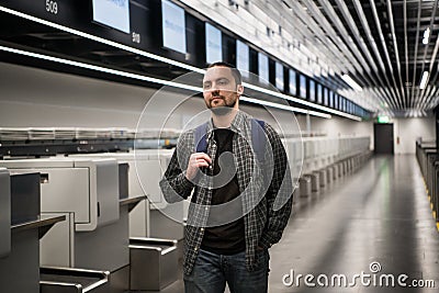 Young passenger with a passport and backpack during registration in airport before flight Stock Photo