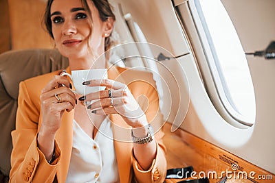 Young passenger woman in yellow clothes is flying in the plane Stock Photo