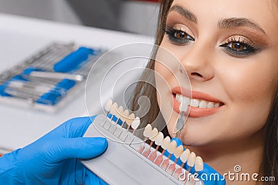 Young patient selects tooth color, crown, veneer, concept of medicine, dentistry and health Stock Photo