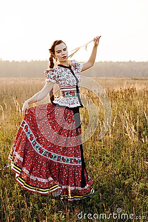 Young peasant woman, dressed in Hungarian national costume, posing over nature background Stock Photo