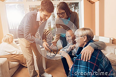 Young people came to visit the older man and woman in a nursing home. Stock Photo