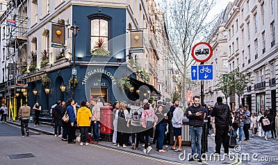 Young people drinking beer near historic pub The Glassblower in Soho, London after work. Editorial Stock Photo