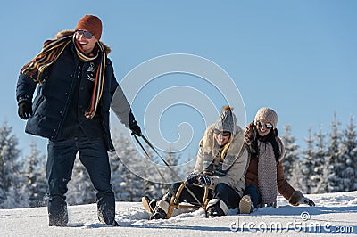 Young people enjoy sunny winter day sledge Stock Photo