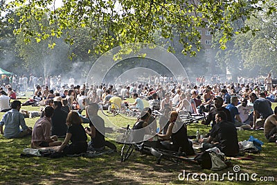 Young people are fried kebabs and rest in a local park in Hackney Editorial Stock Photo