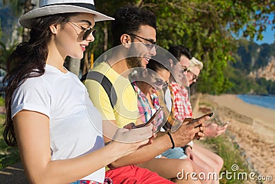 Young People Group Using Cell Smart Phones Tropical Park Palm Trees Friends Chatting Online Holiday Sea Summer Vacation Stock Photo