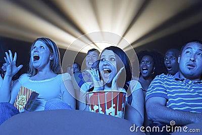 Young People Screaming While Watching Horror Movie In Theatre Stock Photo