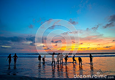 Young people at sunset beach in Kuta, Bali Stock Photo