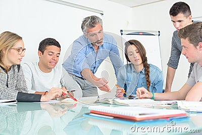 Young people teacher discuss communicate university classroom Stock Photo