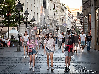 Young people, young man and two young girls, friends, walking wearing face mask protective equipement on Coronavirus Covid 19 Editorial Stock Photo