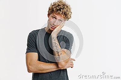 Young perplexed man looking at camera while propping up his head Stock Photo