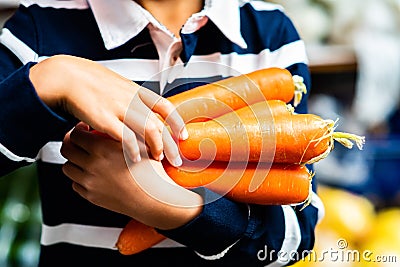 Young Person Carrying Armful of Fresh Organic Carrots Farmers Market Closeup Vegetables Food Stock Photo