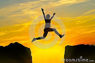 Young person jumping over the mountains Stock Photo